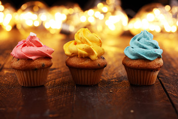 Tasty cupcakes on christmas winter background. Birthday cupcake in rainbow colors.