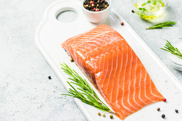 Slice of salmon with pepper, seasalt, herbs and olive oil. Selective focus, space for text.