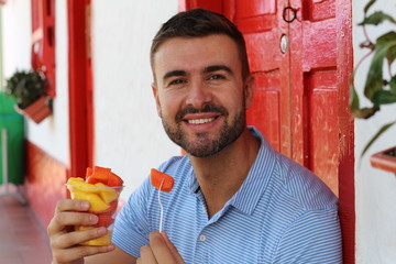 Delighted man eating a fruit platter 