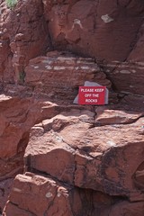 Sedona, Arizona, USA: A sign in the Coconino National Forest asks visitors to keep off of the red sedimentary rocks.