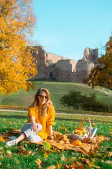 Zelfklevend Fotobehang Woman Sitting Plaid Basket with Food Bakery Autumn Picnic Time Rest Background Old Ruins Background © milenie
