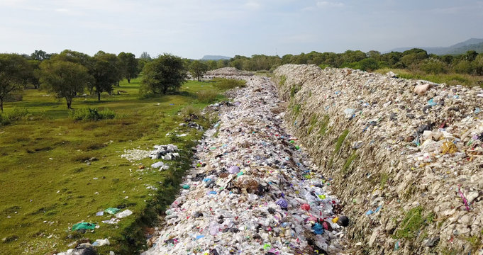 bird's eye view of garbage mountain from dji mavic drone in the industrial zone. see the employees take garbage to sell to earn extra income, this is a very serious risk of pollution.