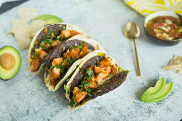 Double-stacked blue corn and flour tortillas tacos