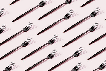 Pattern made of cutlery on pastel background, flat lay, top view. Minimalist concept.