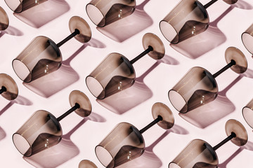 Pattern made of wine glasses on pastel background, flat lay, top view. Fashion Minimalist concept.