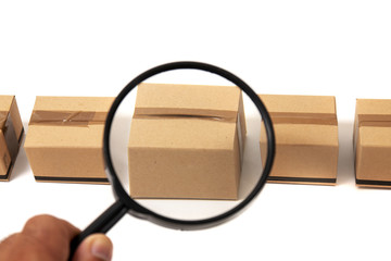 magnifying glass inspecting a cardboard box.