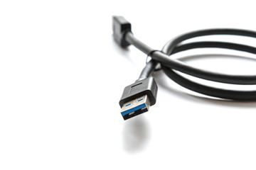 Black USB cable on white background. Connector close-up.