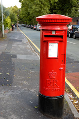Fototapeta na wymiar Red British Royal Mail Postbox Pillar Box On A Street In England
