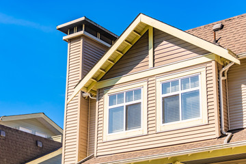 Window on upper level of residential building on blue sky background