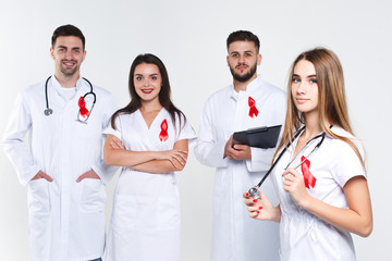 Group of doctors  with watercolor of red ribbon .world AIDS day concept. On the white background.