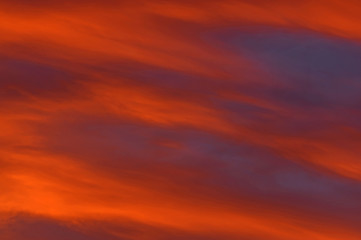 Fototapeta premium Chmury zabarwione na czerwono światłem zachodzącego słońca.