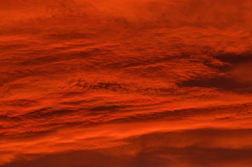 Chmury zabarwione na czerwono światłem zachodzącego słońca.
