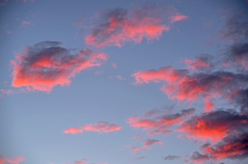 Chmury zabarwione na czerwono światłem zachodzącego słońca.