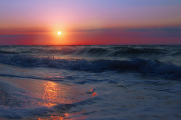Fantastic blue sea background. Mediterranean Sea in the evening. Red sun reflecting in a sea