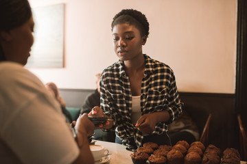 Customer using a credit card to pay for her cappuccino
