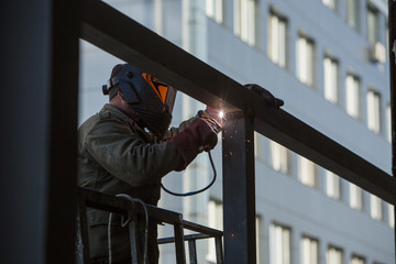 welder builder performs welding work at heights