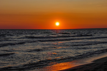 Fototapeta na wymiar The sun sets over the horizon on the sea