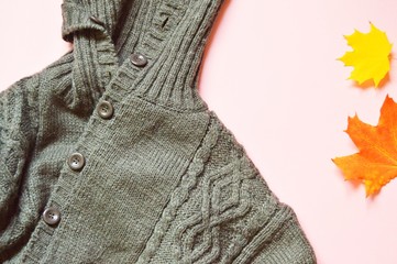 Autumn fashion flat lay photo. Brown woolen sweater and yellow maple leaves