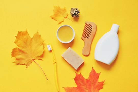 Autumn Skin And Hair Care. Flat Lay Beauty Photo. Toiletries Set. Organic Shampoo, Natural Soap Bar, Toothbrush On A Yellow Background. Bath Products Photography