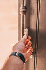 A man opens a vintage wooden shutters