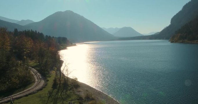 See mit Herbstlandschaft und im Wasser spiegelnder Sonne 4k DCI 50p