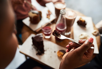 Young woman eating cake with friends in a cafe