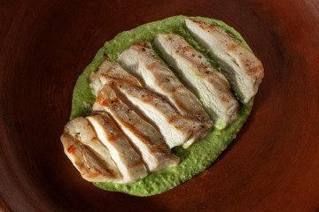 Marinated grilled chicken breasts cooked. On a clay plate.