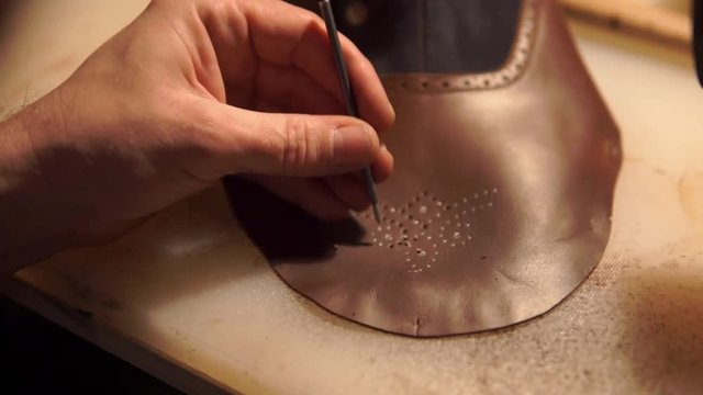 ancient workshop with expert shoemaker during the processing of leather to produce shoes with vintage effect