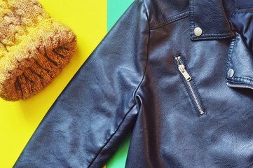 Yellow woolen hat and trendy faux leather jacket. Flat lay autumn women's outfit. Ladies wear