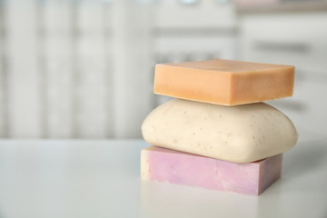 Stack of different soap bars on table. Space for text