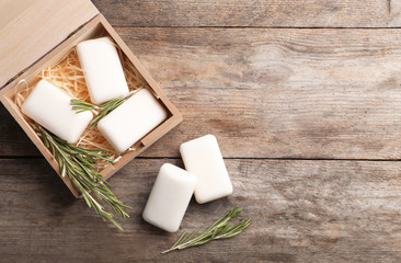 Flat lay composition with soap bars, rosemary and space for text on wooden background © New Africa