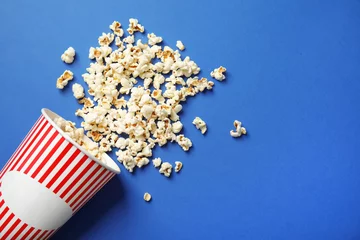 Deurstickers Paper cup and tasty popcorn on color background, top view with space for text. Cinema snack © New Africa