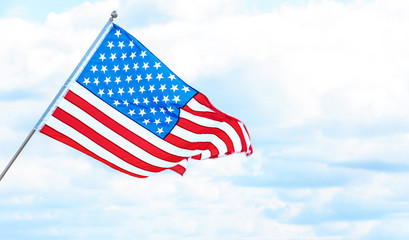 American flag near river on cloudy day. Space for text