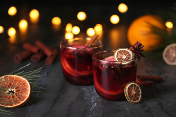 Mulled wine with cinnamon, anise and orange in glasses on table