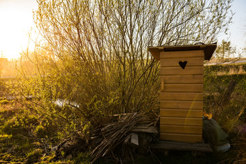Traditional old wooden outhouse in the garden in summer