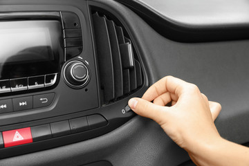 Woman adjusting air conditioner in car, closeup
