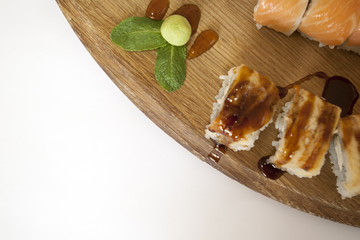 Sushi hand rols on a babmboo plate, background