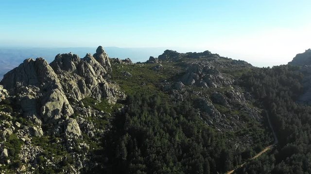 Video from above, aerial view of a beautiful valley surrounded by granite mountains and green vegetation, Monte Limbara, Sardinia, Italy.