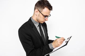 businessman in glasses and suit holding an empty sheet of paper, writing plans for the coming year, on a white background