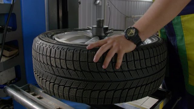 4K tyre fitter is disassembling tyre from a wheel