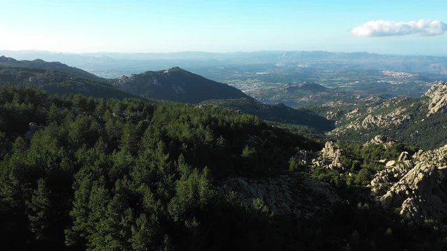 Video from above, aerial view of a beautiful valley surrounded by granite mountains and green vegetation, Monte Limbara, Sardinia, Italy.