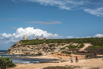Capo Mannu Cliffs with blue sky, dramatic clouds and some unrecognizable cyclists. Shot in Capo...
