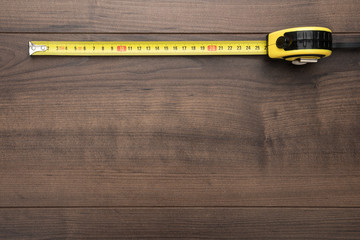 tape measure on the brown wooden background