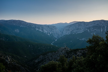 Panoramic Mountain Landscape view at dusk, with layered blue mountains and river, Sardinia, Orosei region.