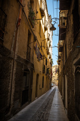 Narrow streets of Cagliari in Sardinia, Italy. Streets are so narrow that it is dark on a sunny day. Nobody in the scene.