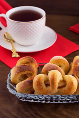 Preparation of Breakfast - homemade cakes with filling, tea in a white porcelain mug, wooden background.