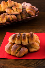 Breakfast of baked pastries with tea in a white mug, wooden background.