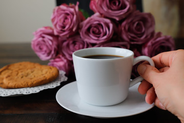 a female hand holds a mug of coffee