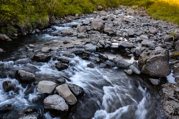 View in Skaftafell national park to the river and stones, water in motion blur, Iceland in summer