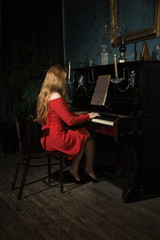 Beauty woman in evening dress playing piano